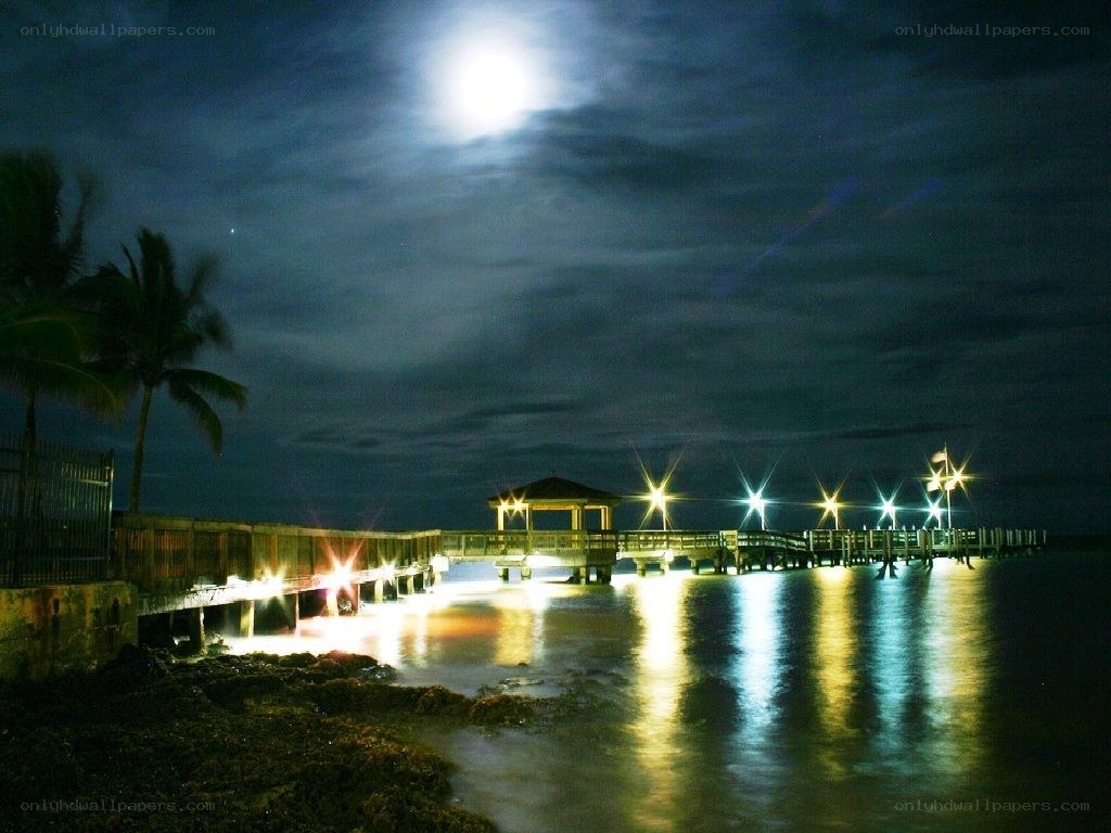 Moonlit pier at night