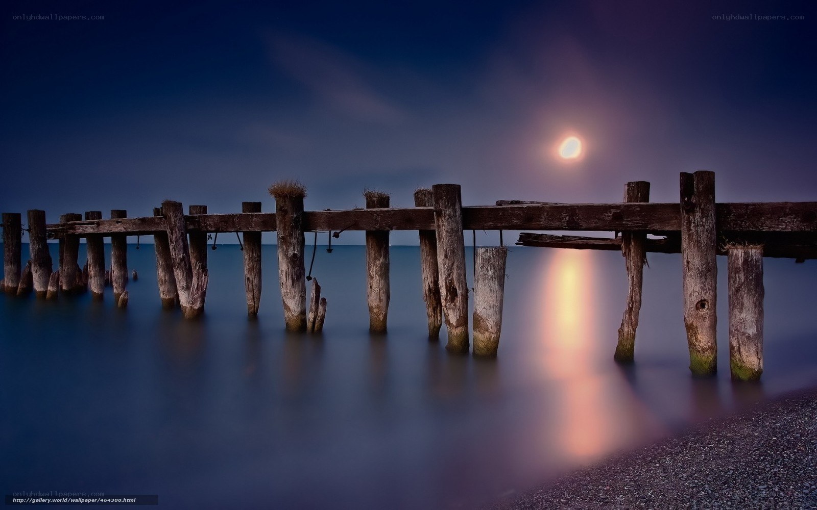 Moonlit pier at night