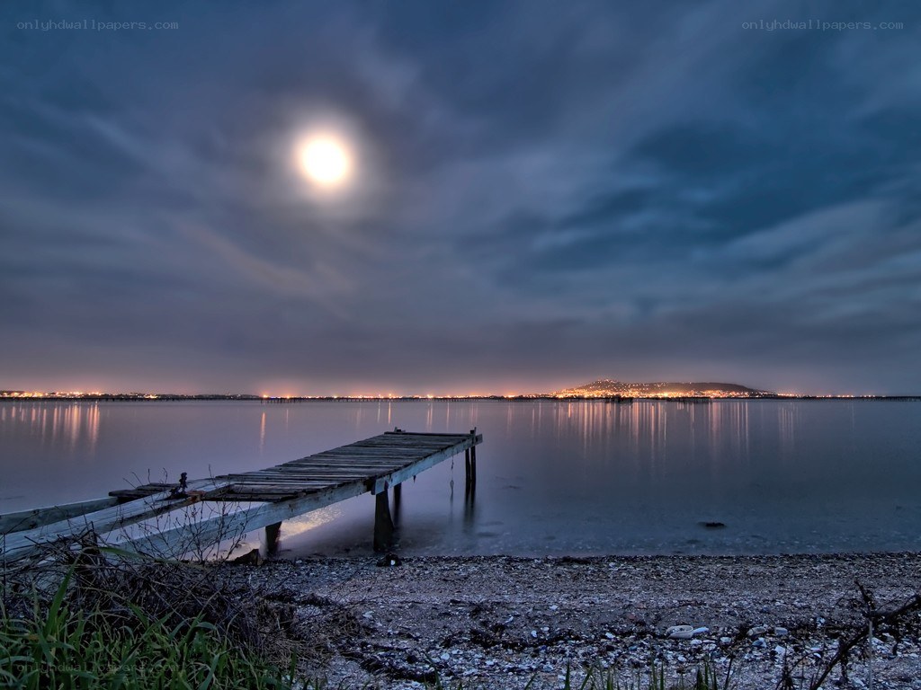 Moonlit pier at night