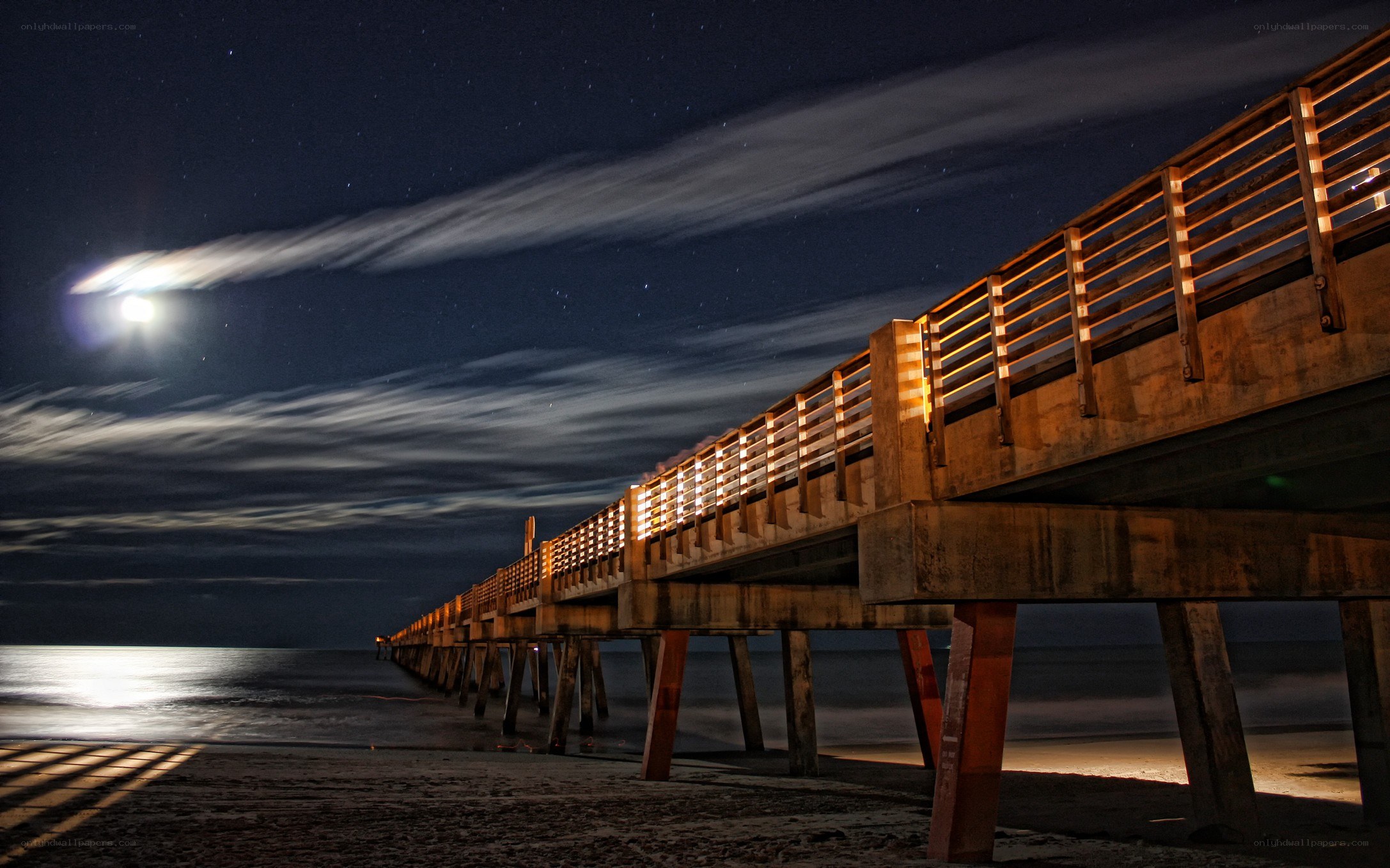 Moonlit pier at night