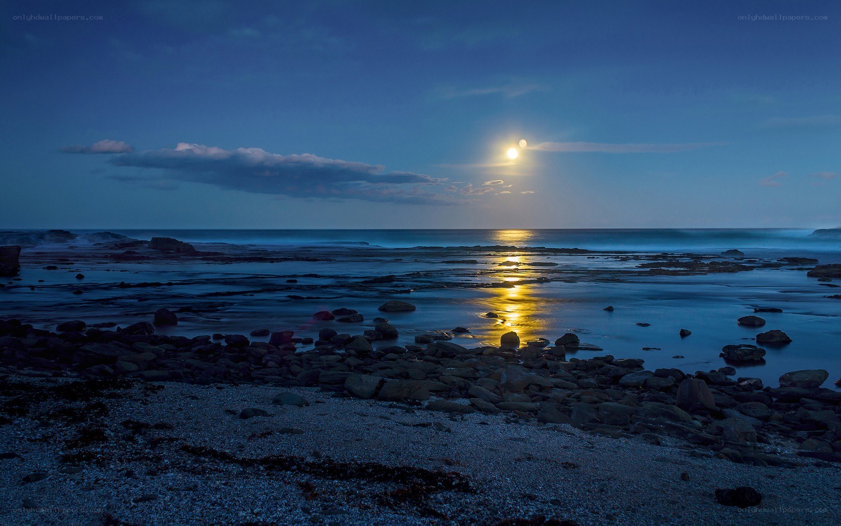 Moonlit rocky beach at dusk