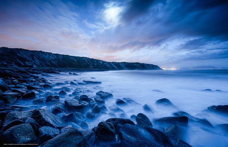 Moonlit rocky coastline at dusk