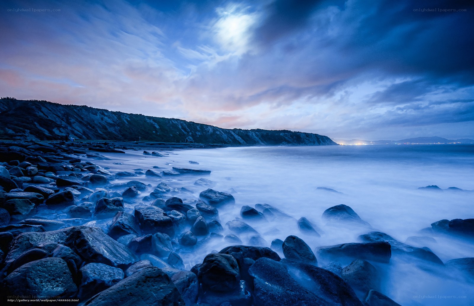 Moonlit rocky coastline at dusk