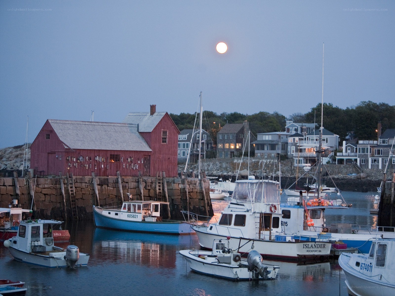 Moonrise over a coastal harbor