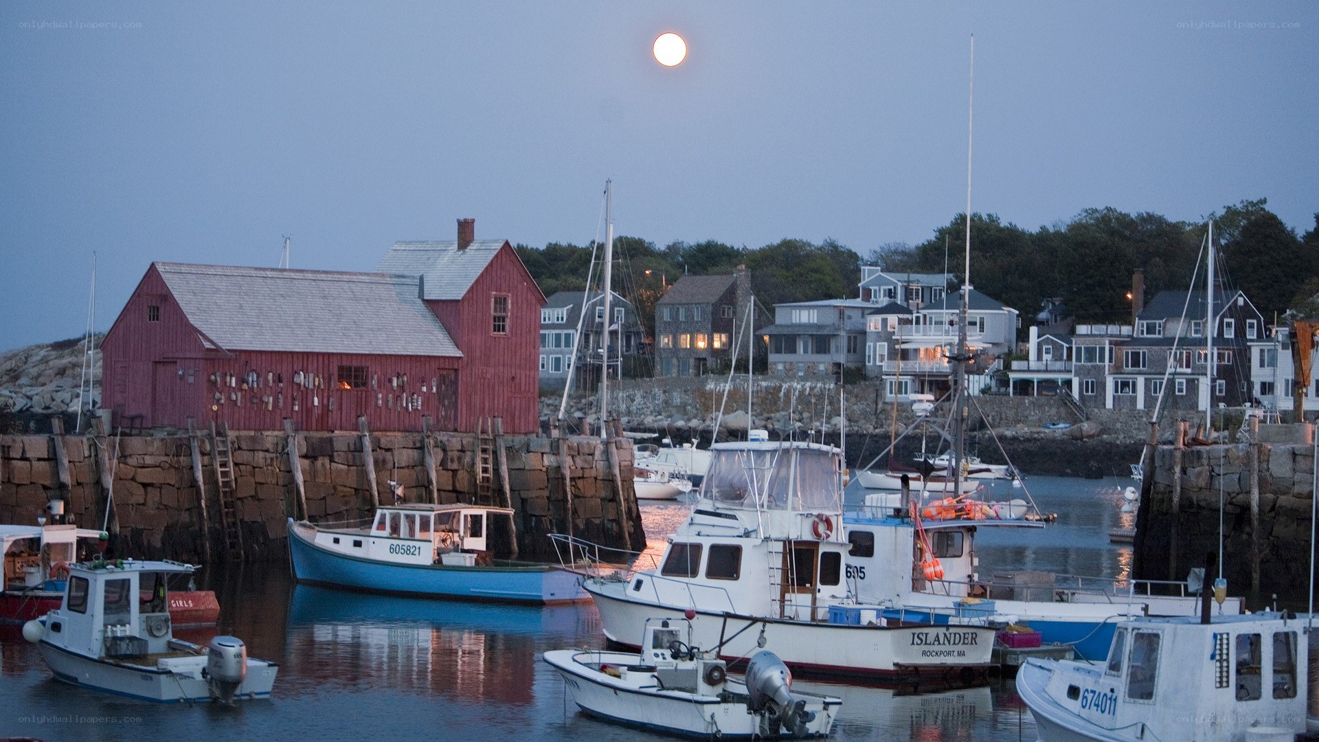Moonrise over a coastal harbor