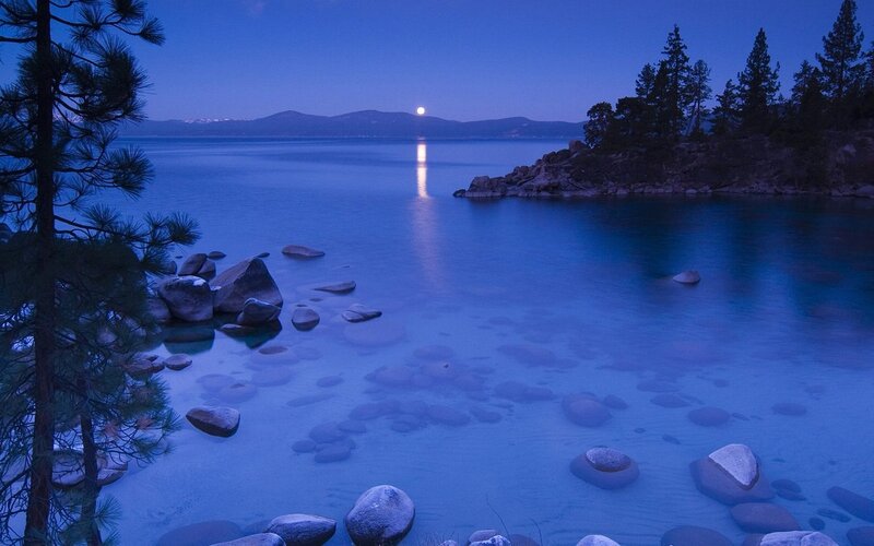 Moonrise over a serene lake