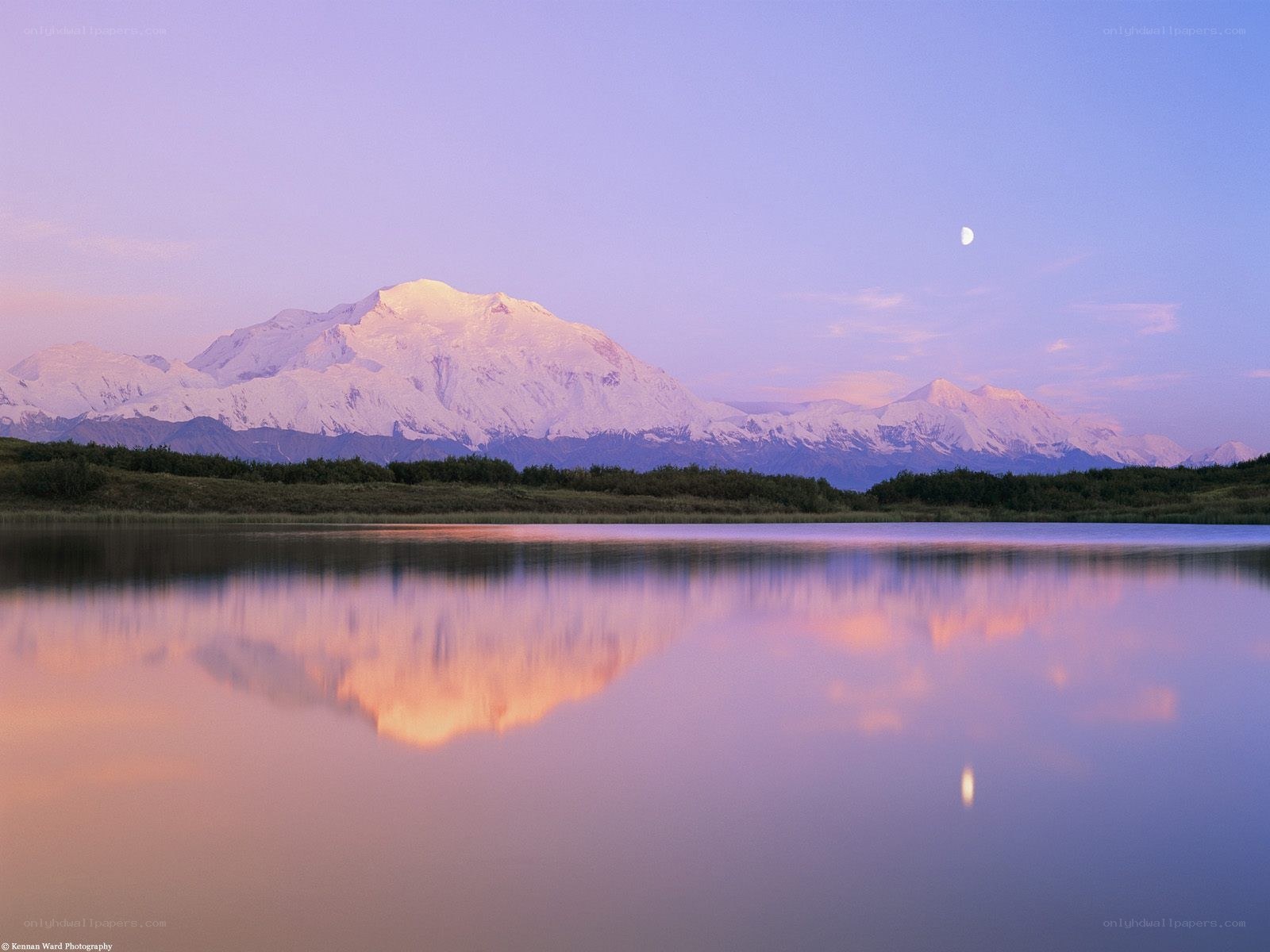 Moonrise over a snow-capped mountain