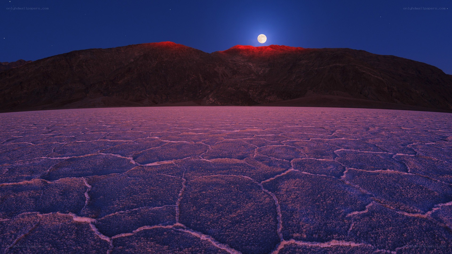 Moonrise over cracked desert