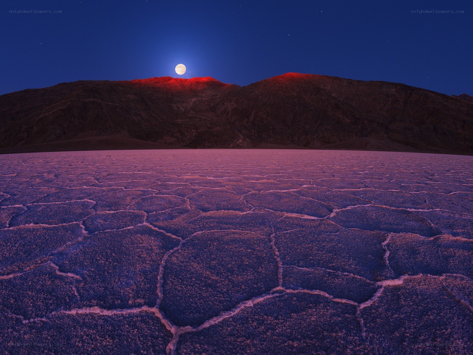 Moonrise over cracked desert
