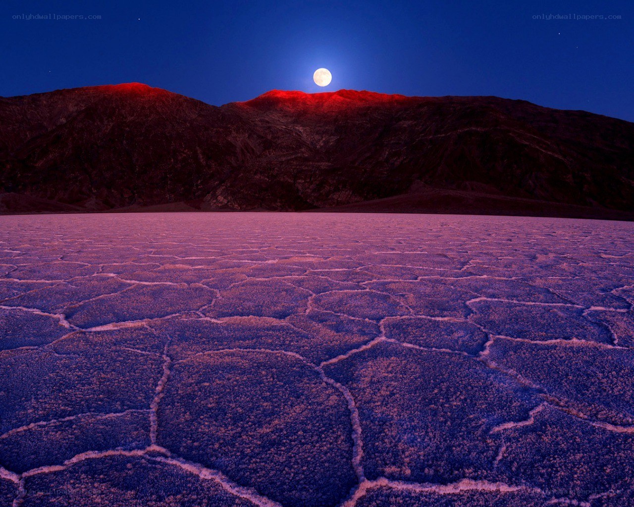 Moonrise over cracked desert