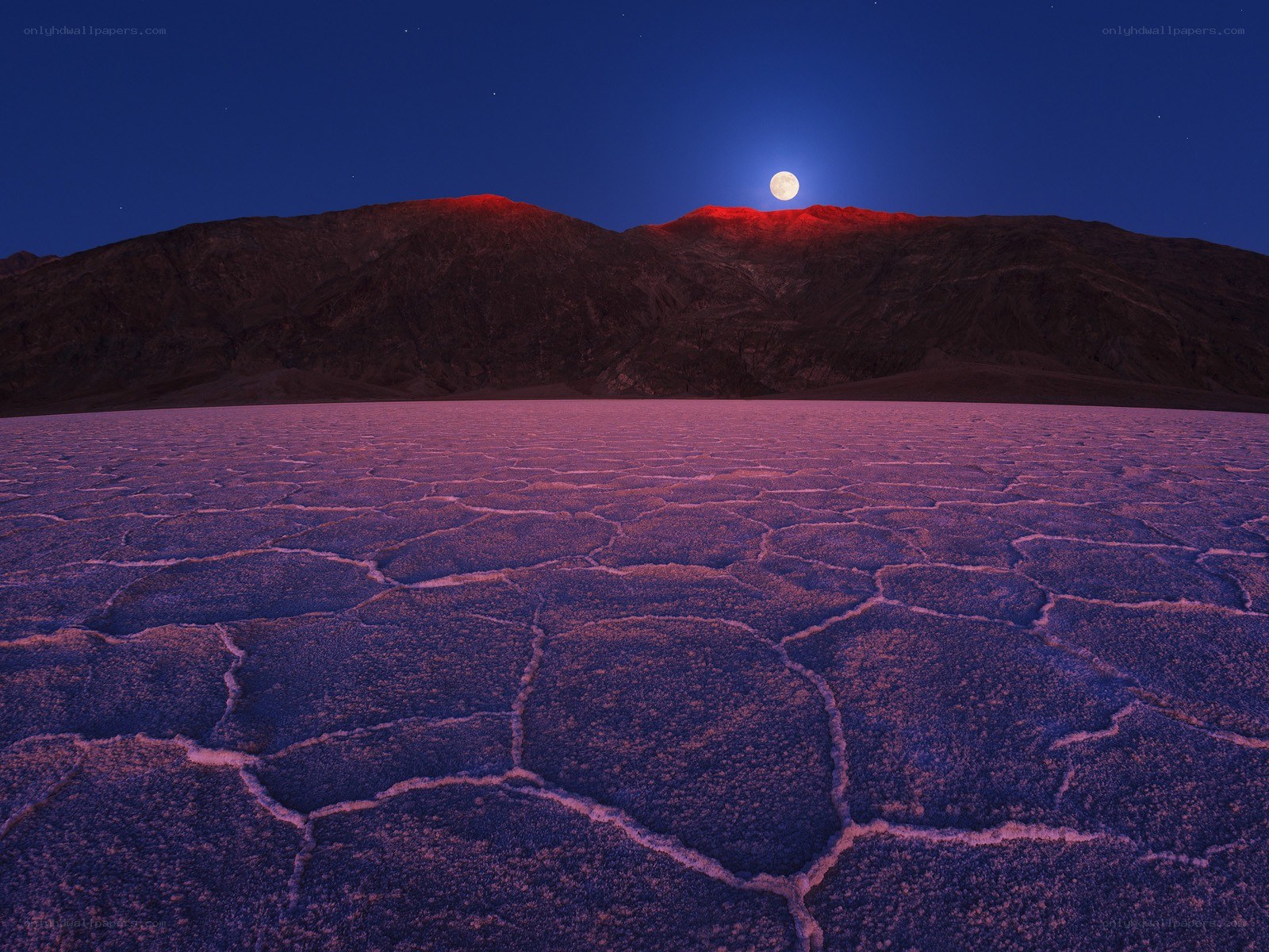 Moonrise over cracked desert