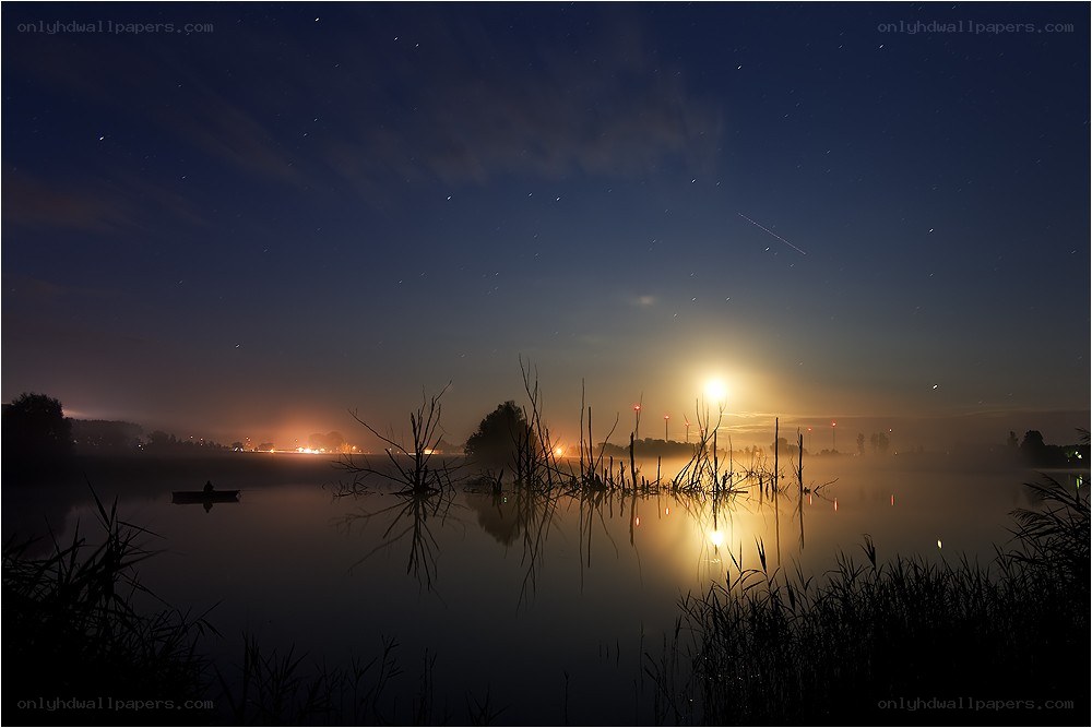 Moonrise over misty lake