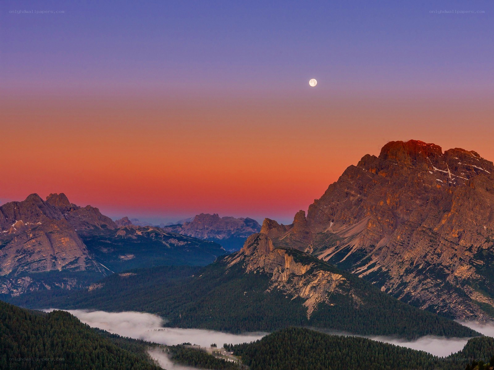 Moonrise over mountain peaks