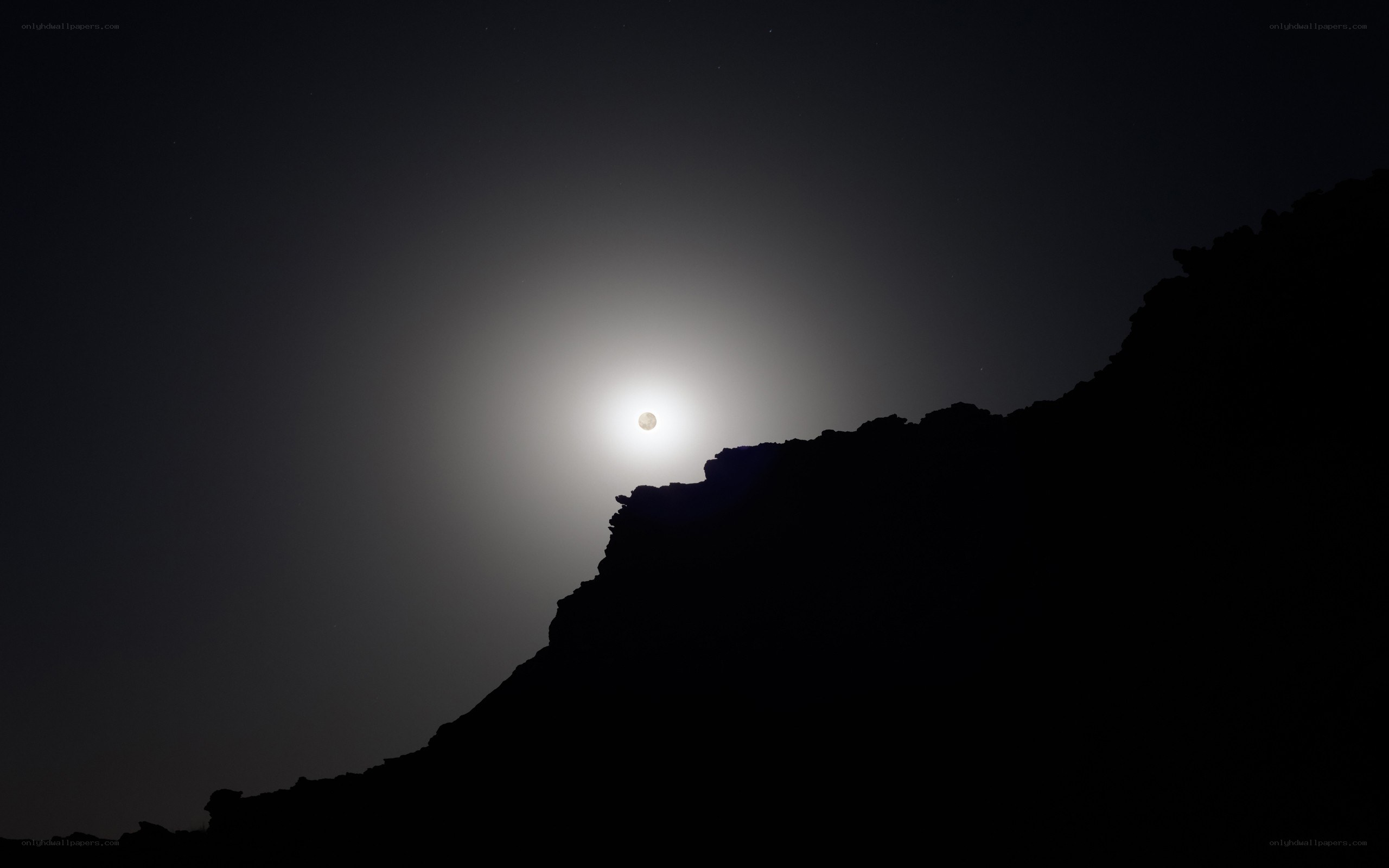 Moonrise over mountain silhouette