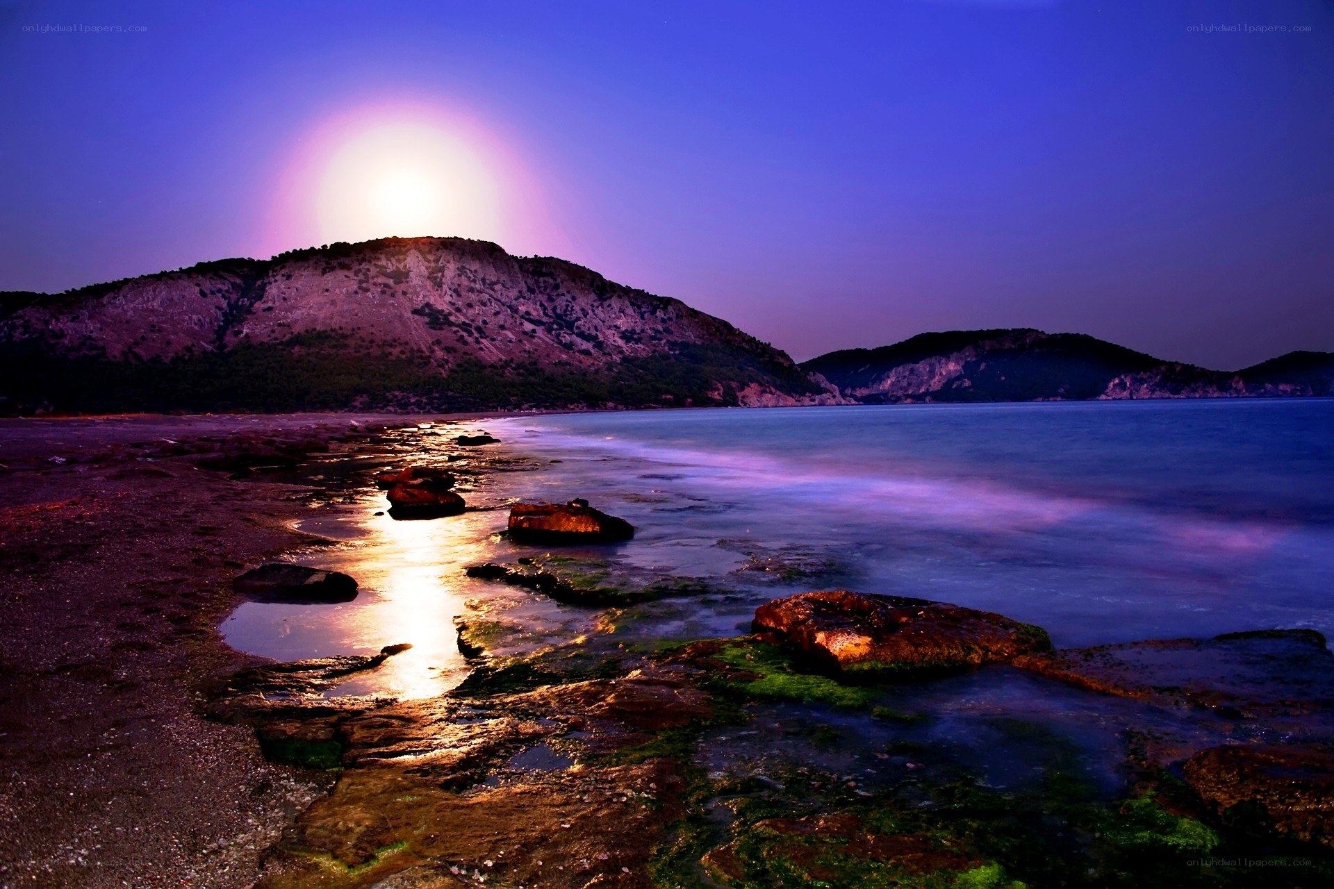 Moonrise over rocky coastline