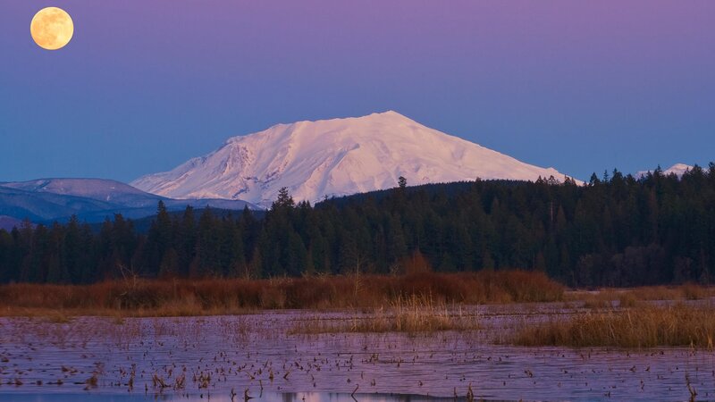 Moonrise over snow-capped mountain