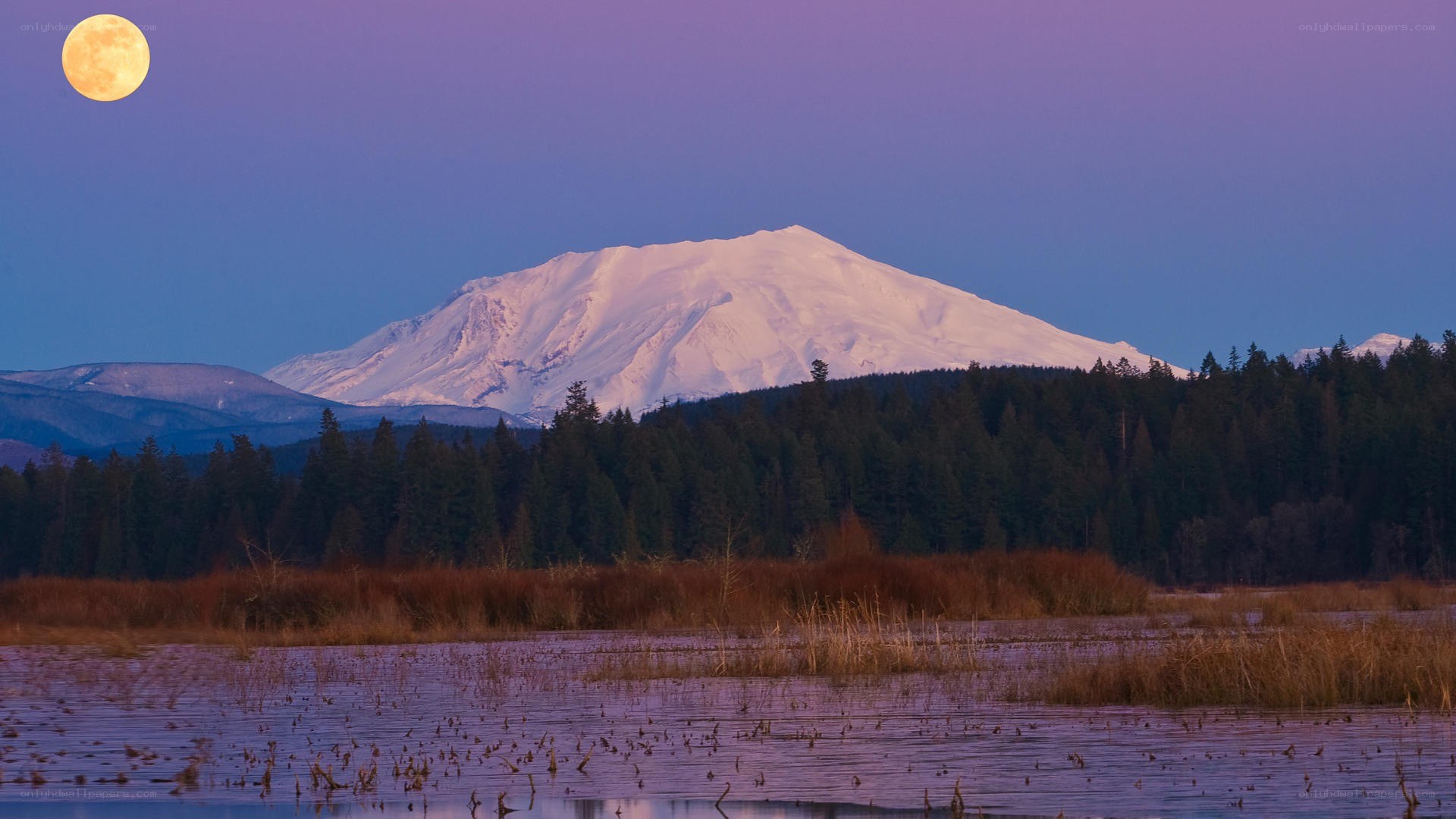 Moonrise over snow-capped mountain