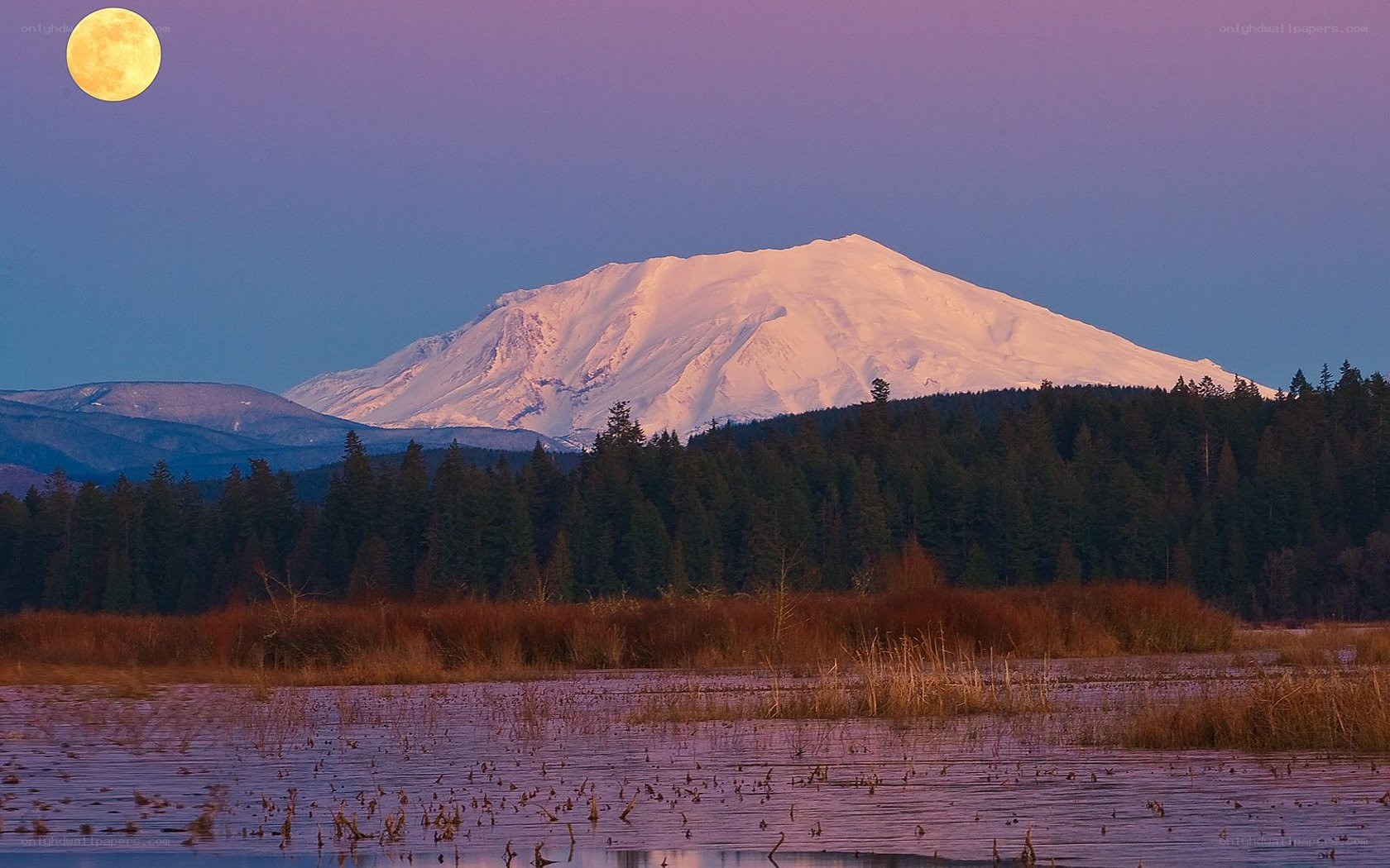 Moonrise over snow-capped mountain