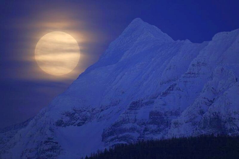 Moonrise over snow-capped mountain