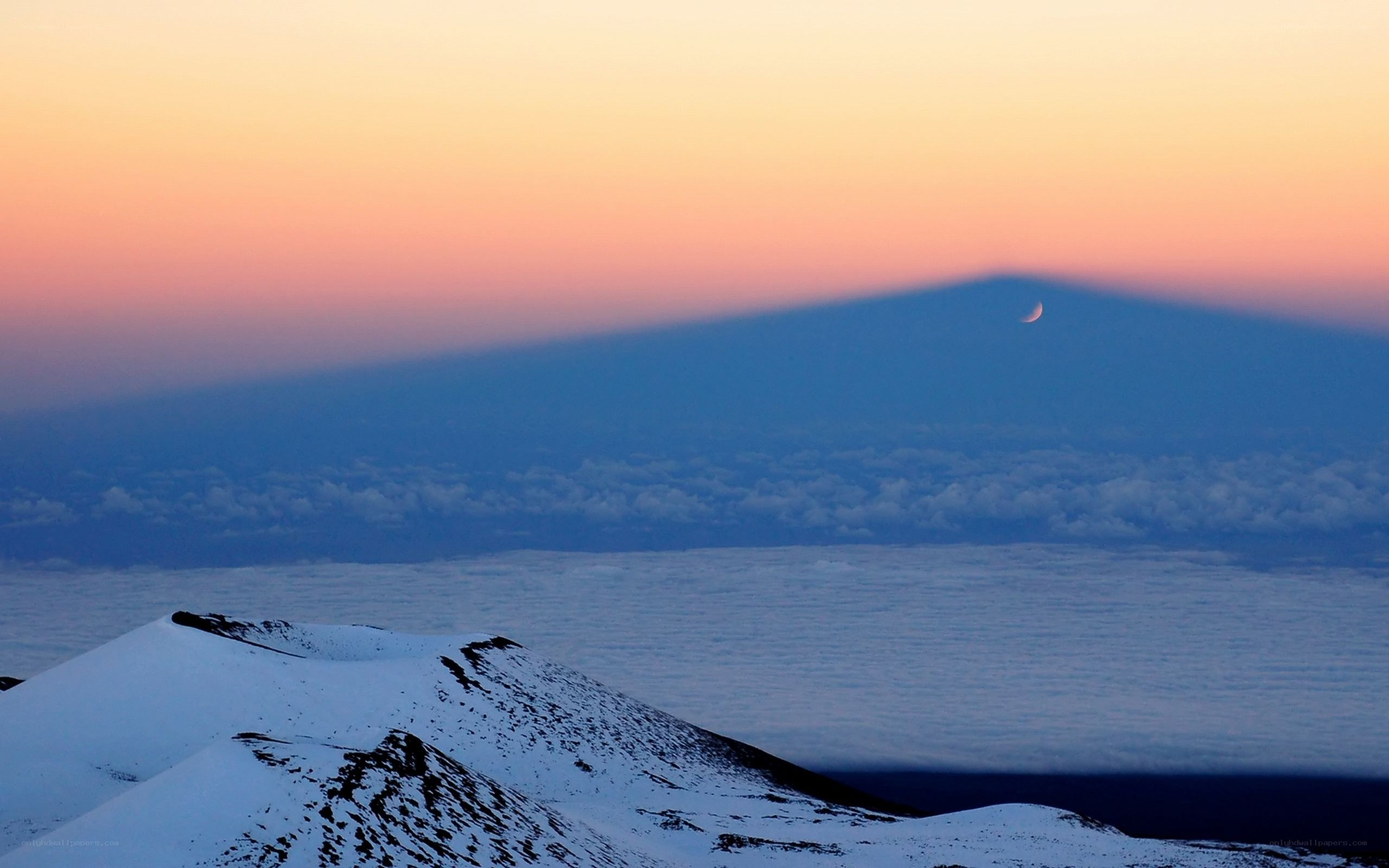 Moonrise over snow-capped mountain