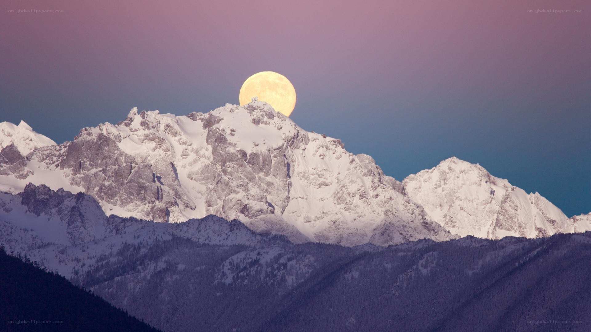 Moonrise over snow-capped mountains