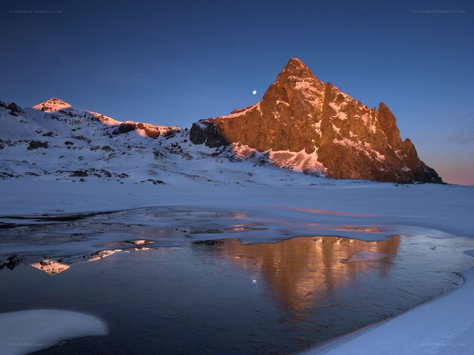 Moonrise over snowy mountain