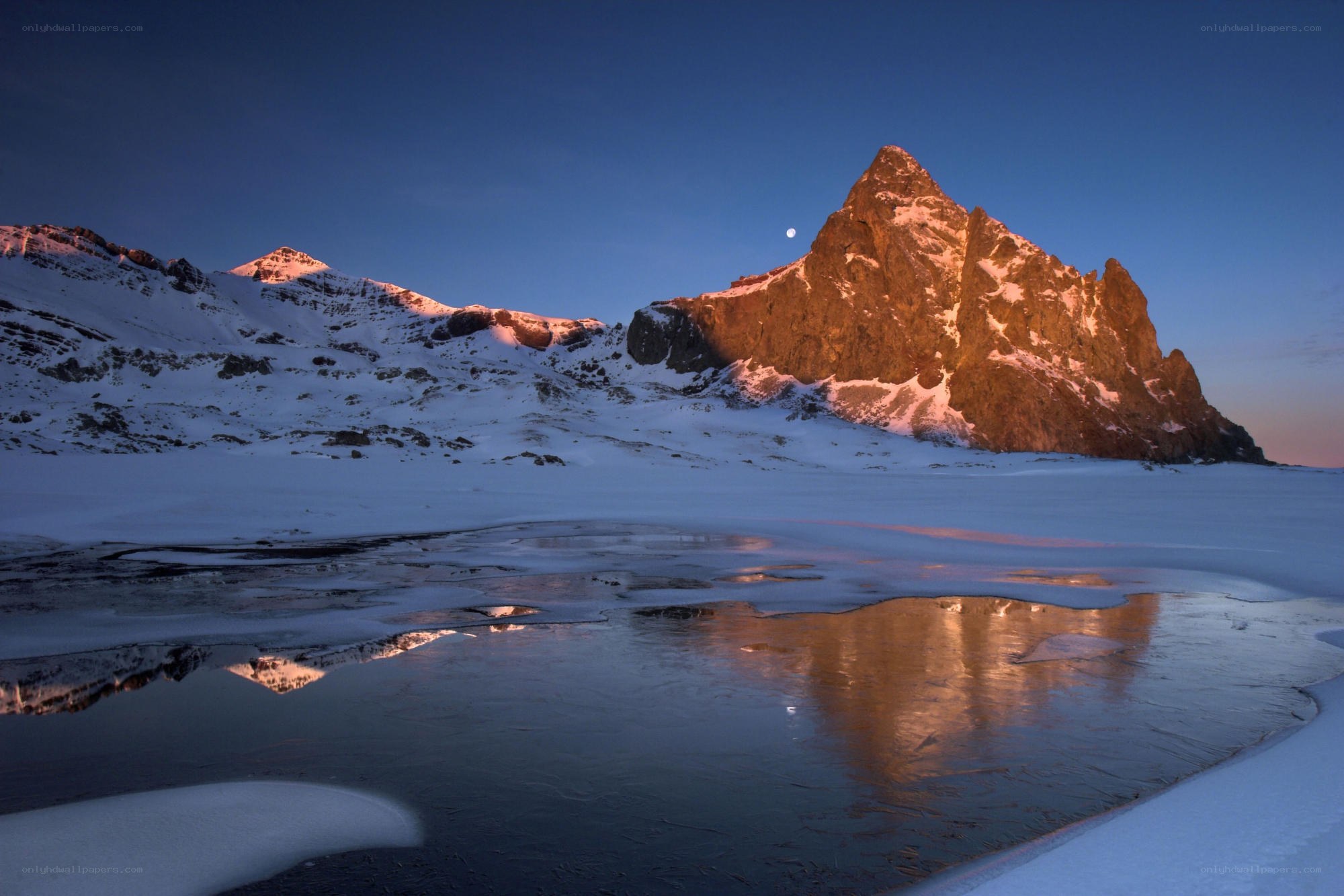 Moonrise over snowy mountains