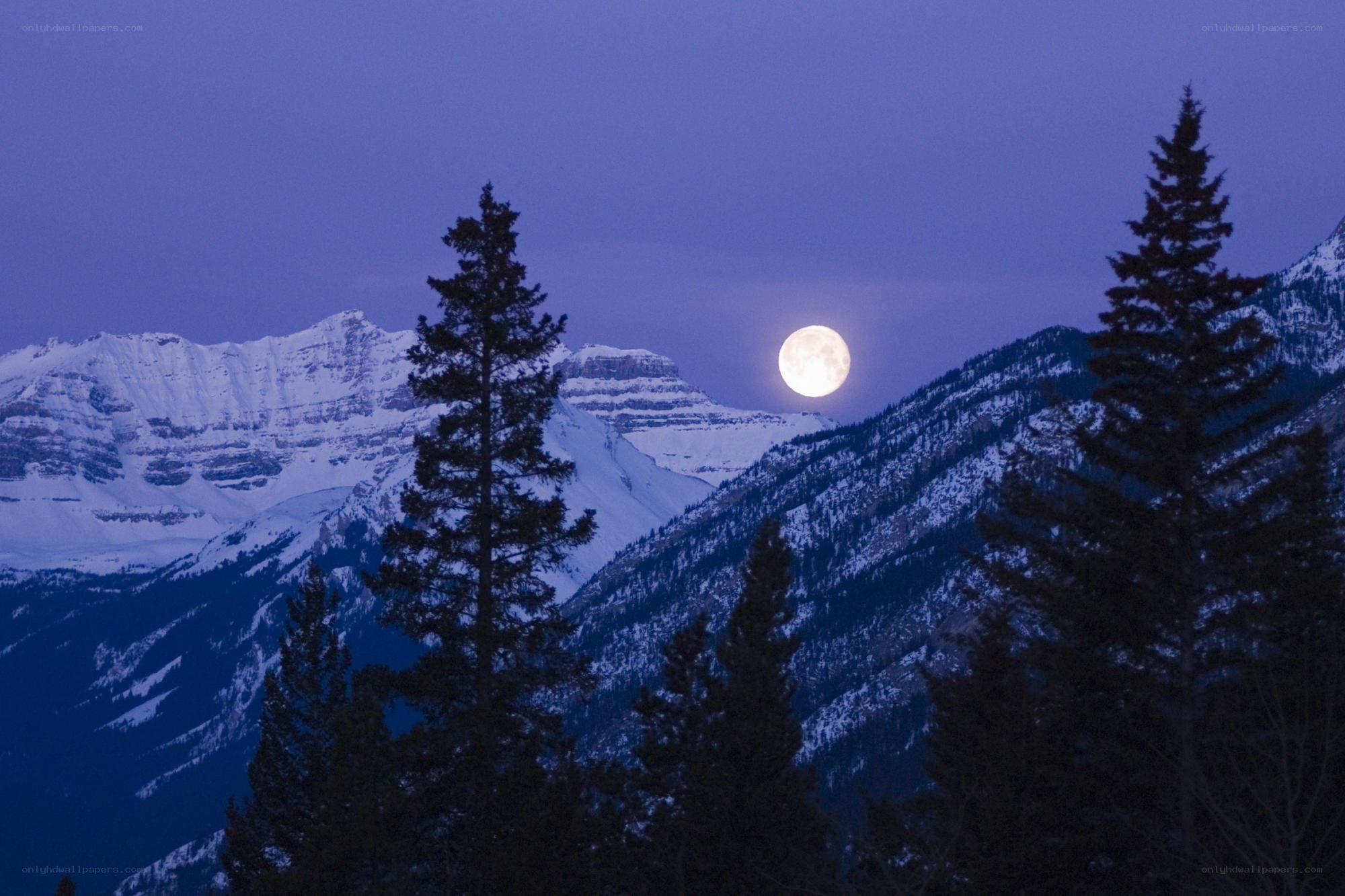 Moonrise over snowy mountains