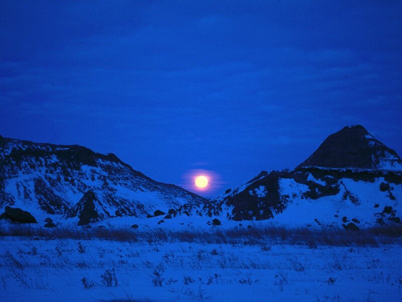 Moonrise over snowy mountains