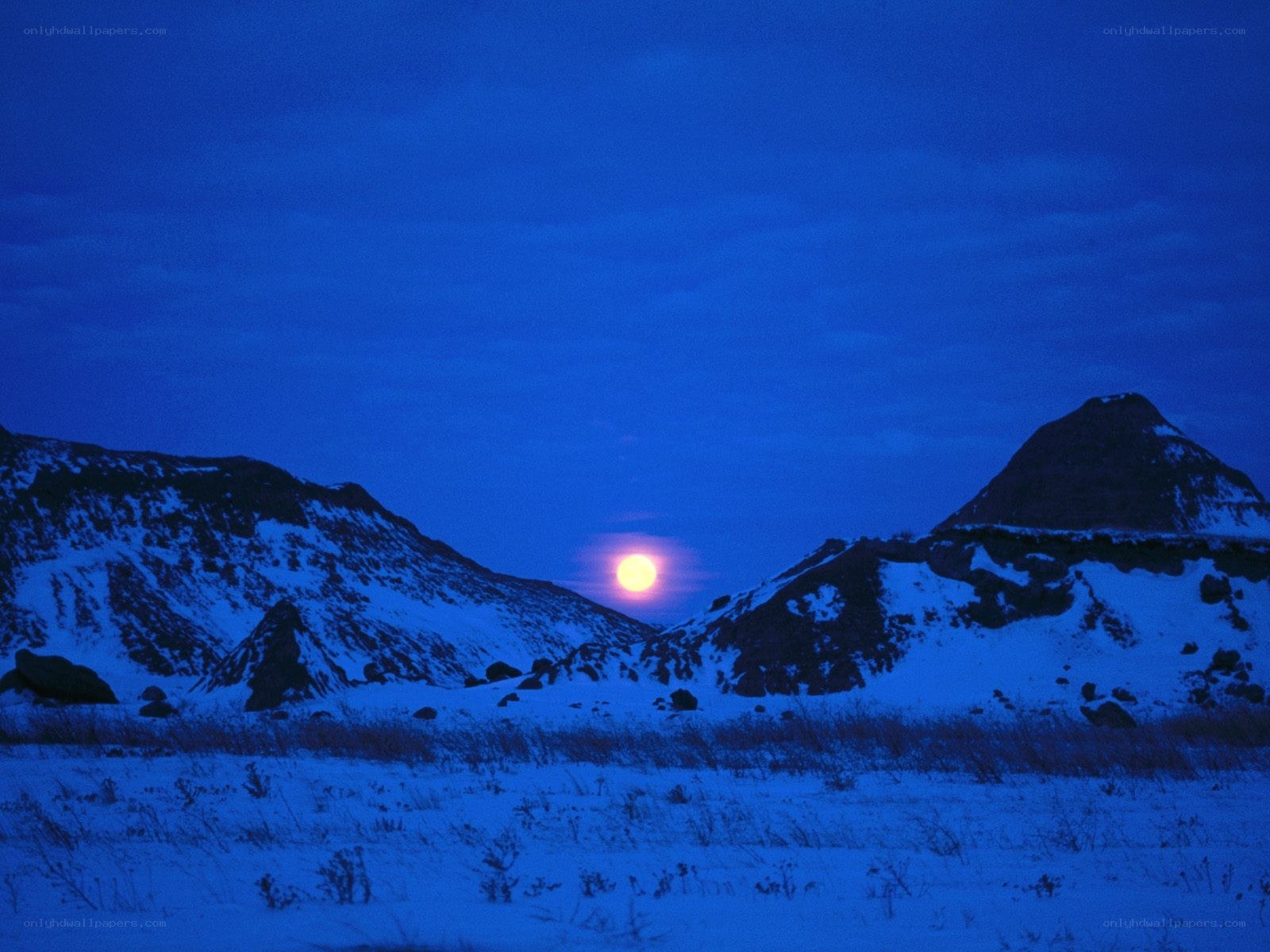 Moonrise over snowy mountains