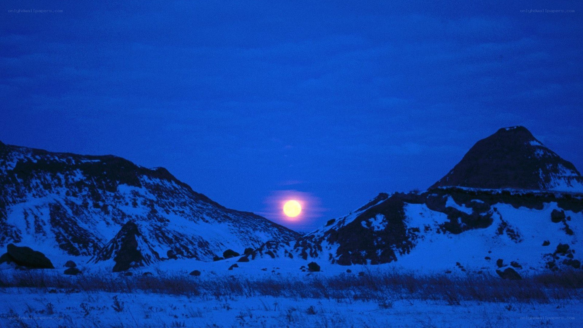 Moonrise over snowy mountains