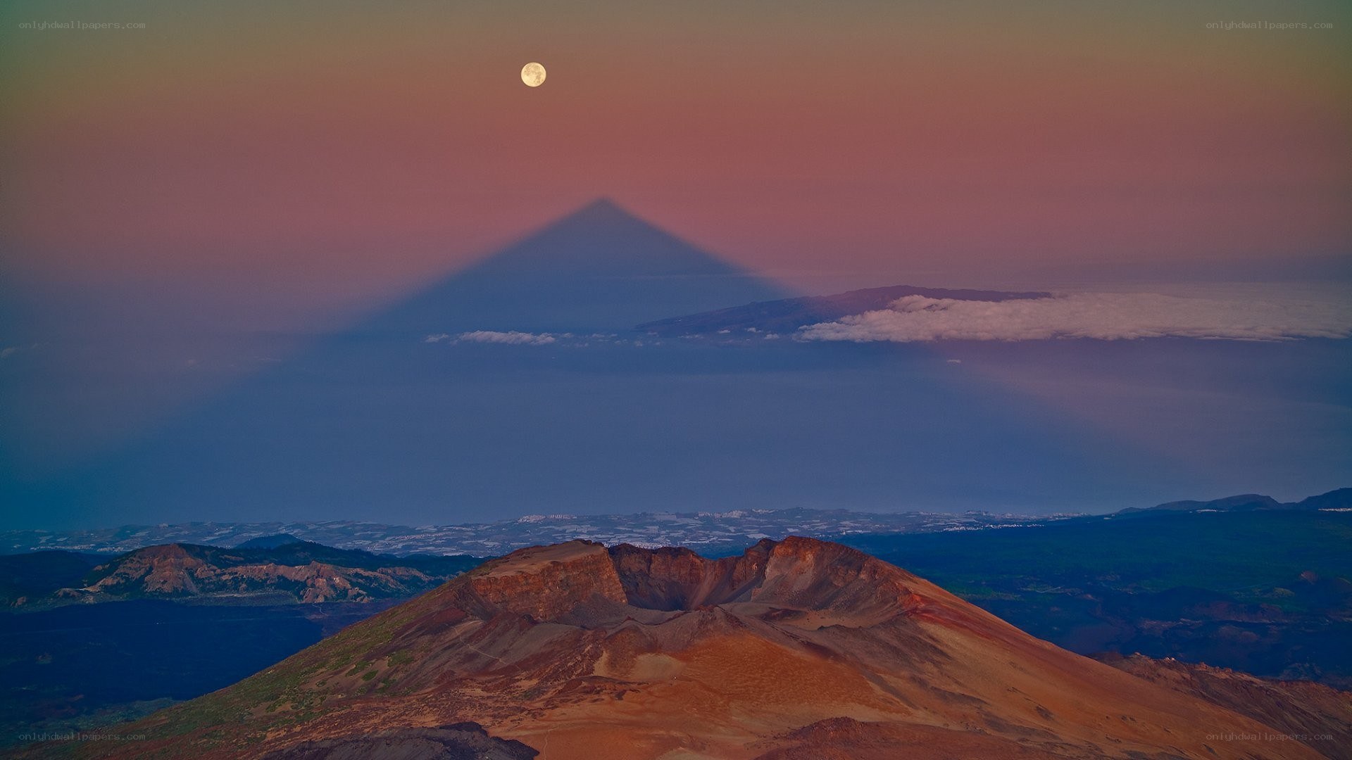 Moonrise over volcanic landscape