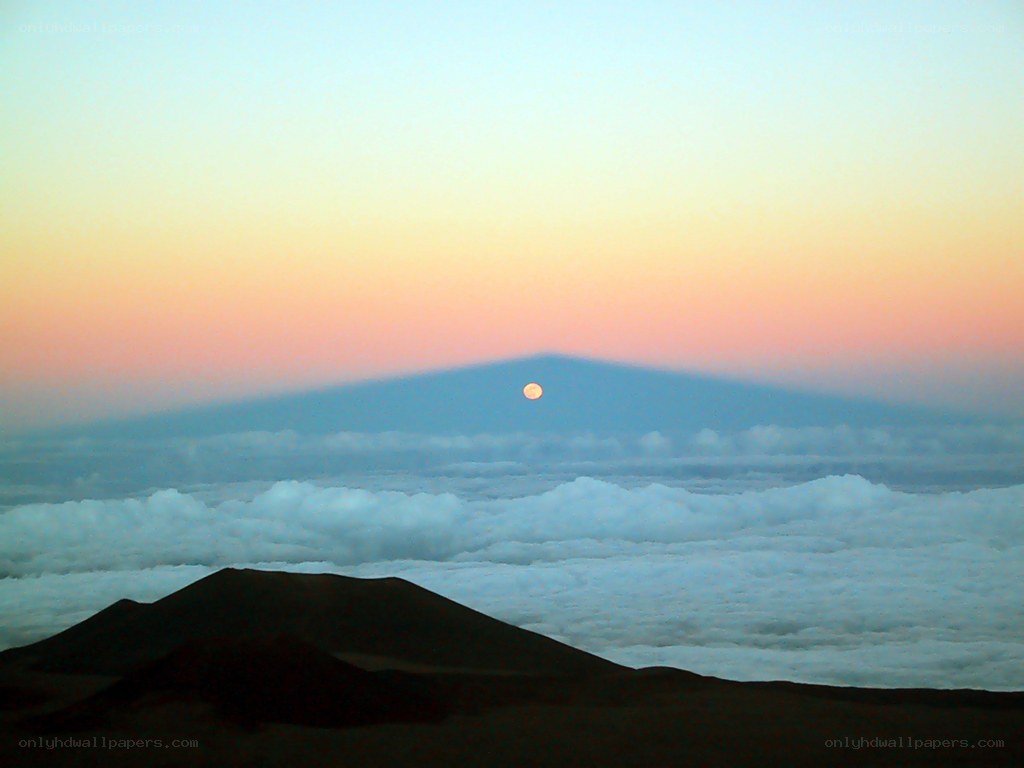 Moonrise over volcanic landscape