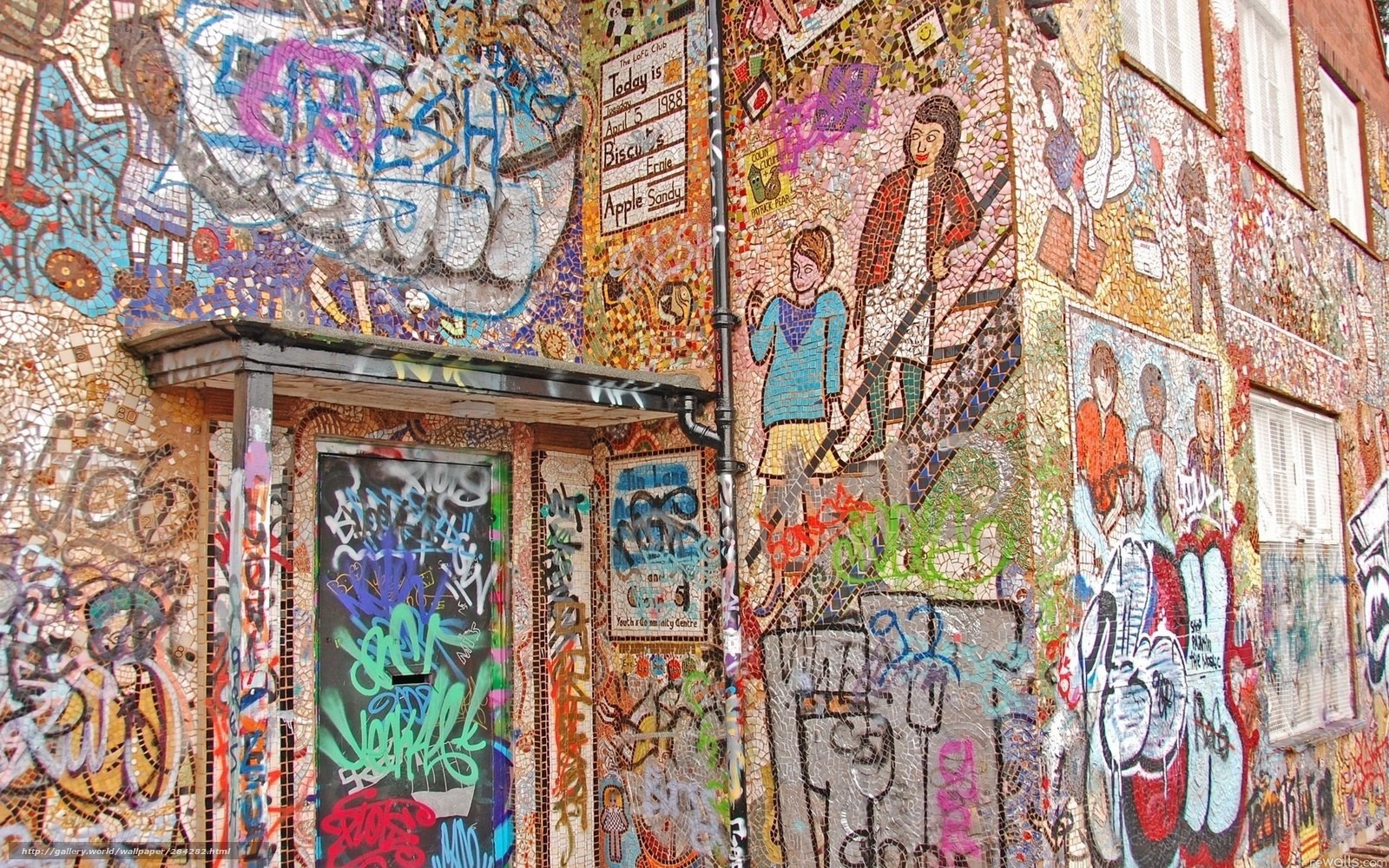 mosaic-covered building with graffiti