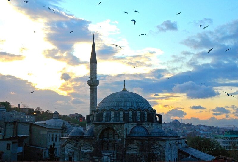 Mosque at sunset with birds