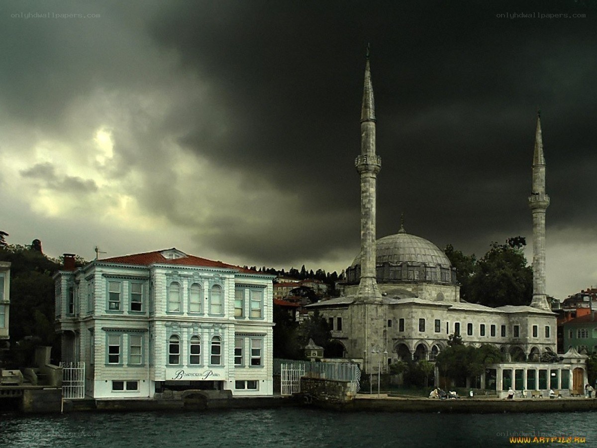 Mosque by the water under stormy sky