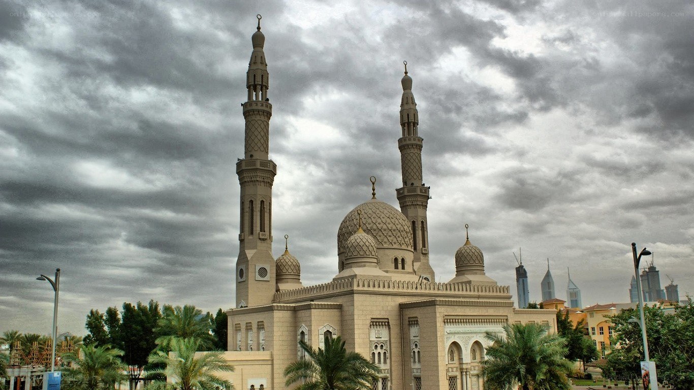 mosque with minarets under cloudy sky