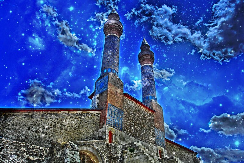 Mosque with minarets under starry sky