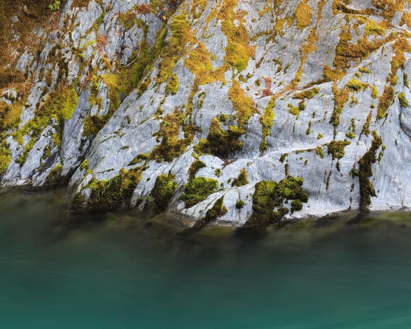 moss-covered rocks by water