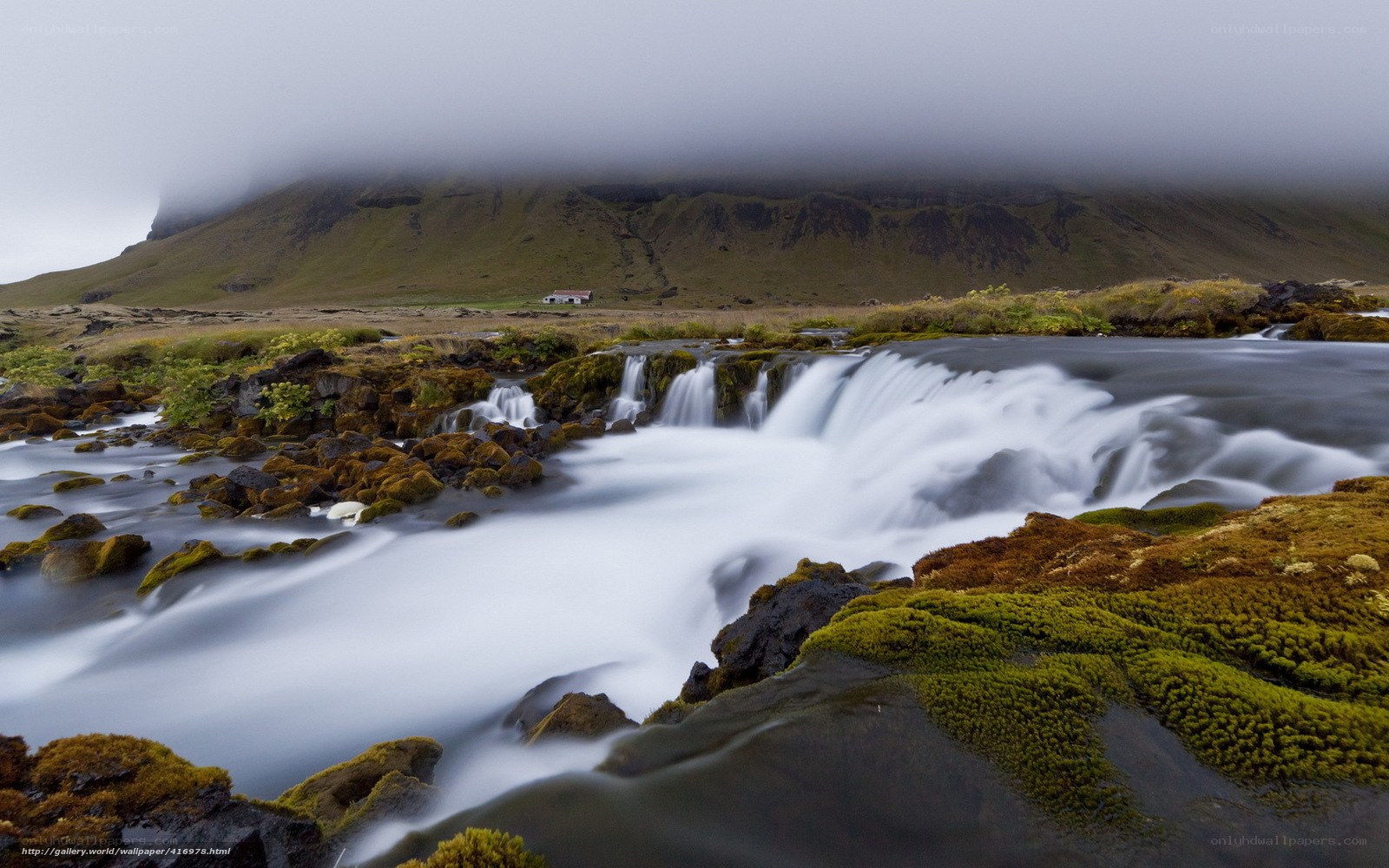 Mossy waterfall in foggy landscape