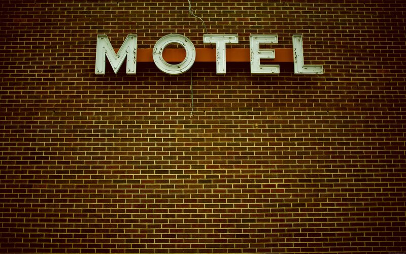 Motel sign on brick wall