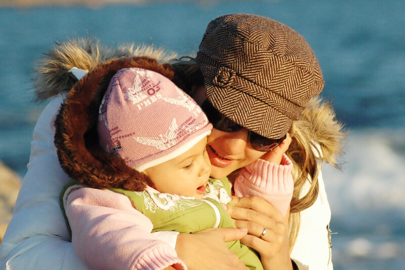Mother and child hugging by the sea