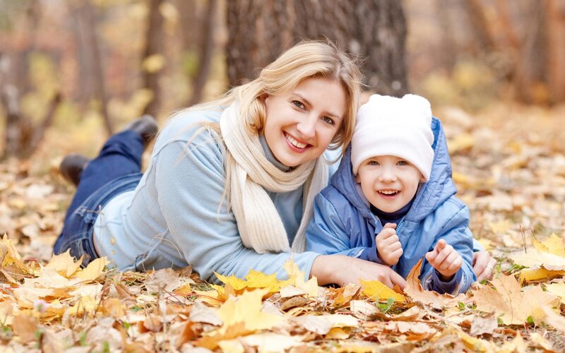 Mother and child in autumn leaves