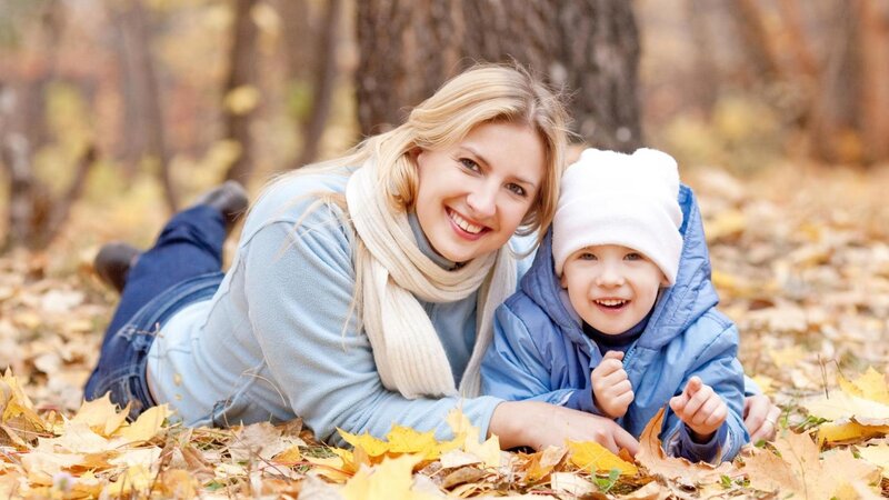 Mother and child in autumn leaves