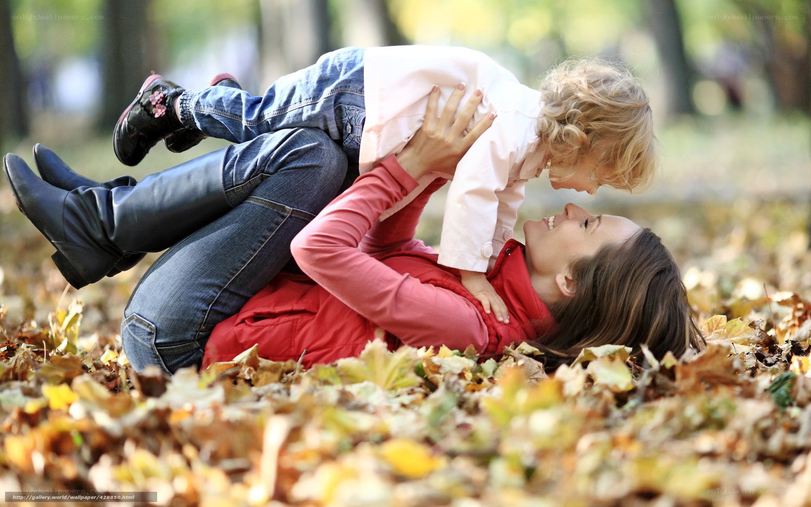 Mother and child playing in autumn leaves