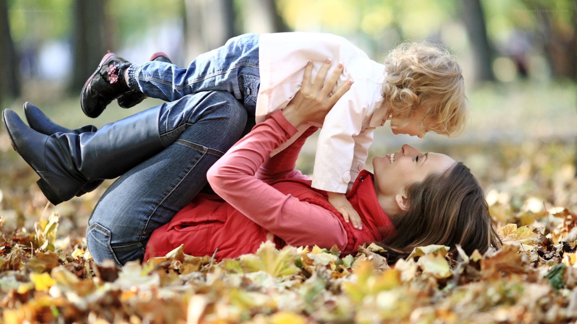 Mother and child playing in autumn leaves