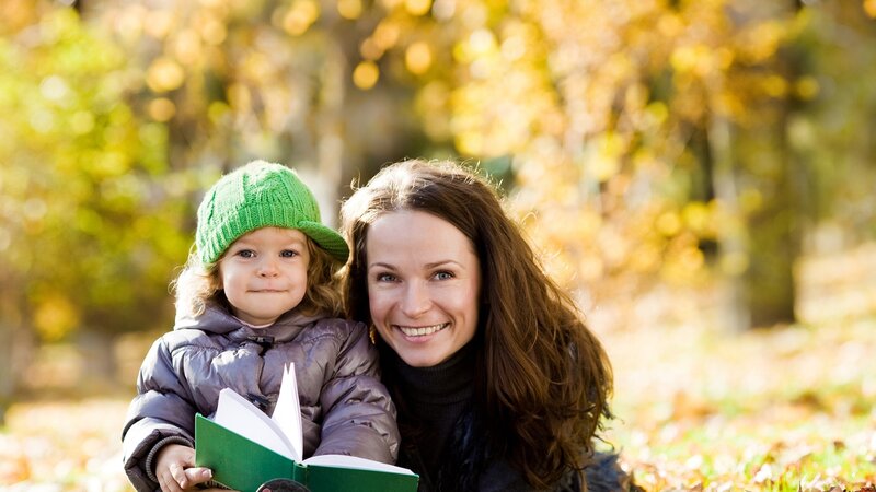 Mother and child reading in autumn