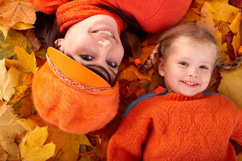 Mother and daughter in autumn leaves