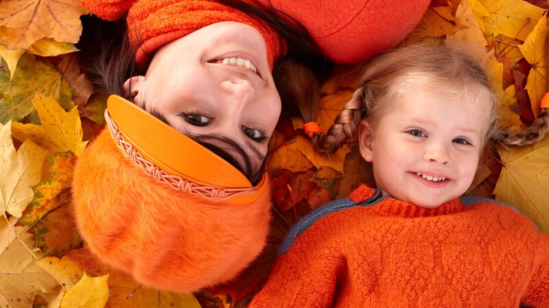 Mother and daughter in autumn leaves