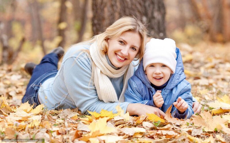 Mother and son in autumn leaves